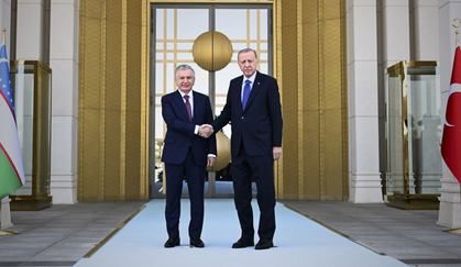 Özbekistan Cumhurbaşkanı Şevket Mirziyoyev, Türkiye’ye resmi bir ziyaret gerçekleştirdi. Cumhurbaşkanı Recep Tayyip Erdoğan, Mirziyoyev’i Esenboğa Havalimanı’nda resmi törenle karşıladı. Karşılama programında Emine Erdoğan, Cumhurbaşkanı Yardımcısı Cevdet Yılmaz ve üst düzey yetkililer de yer aldı. Mirziyoyev, Muhafız Alayı Tören Kıtası’nı Türkçe “Merhaba asker” diyerek selamladı. Cumhurbaşkanlığı Külliyesi’nde gerçekleşen ikili görüşmenin ardından iki lider, ortak basın toplantısında kapsamlı açıklamalarda bulundu. Cumhurbaşkanı Erdoğan, Türkiye ile Özbekistan arasındaki ilişkilerin “kapsamlı stratejik ortaklık” seviyesine yükseltildiğini vurgulayarak, iki ülke arasındaki ebedi dostluk ve iş birliği anlaşmasının 30. yıl dönümünün idrak edildiğini hatırlattı. Ticarette Yeni Hedef: 5 Milyar Dolar Cumhurbaşkanı Erdoğan, son 10 yılda Türkiye ile Özbekistan arasındaki ticaret hacminin üç kat arttığını belirterek, yeni hedefin 5 milyar dolar olduğunu açıkladı. Siyasi, ekonomik, kültürel ve beşeri alanlarda kurumlar arası iş birliğinin güçlenerek sürdüğünü ifade eden Erdoğan, Türk şirketlerinin Özbekistan’da en fazla yatırım yapan ilk üç ülke arasında yer aldığını söyledi. Erdoğan, Özbekistan’ın Orta Asya’da bölgesel entegrasyonda öncü bir rol üstlendiğini belirterek, Türk Devletleri Teşkilatı çatısı altındaki iş birliğinin de giderek derinleştiğini dile getirdi. Semerkant’ta düzenlenen UNESCO Genel Konferansı’nda 15 Aralık’ın “Dünya Türk Dili Günü” ilan edilmesine Özbekistan’ın verdiği katkıya da teşekkür etti. Hatay’a Konut Desteği ve Deprem Dayanışması Basın toplantısında deprem dayanışmasına da özel bir parantez açıldı. Cumhurbaşkanı Erdoğan, Özbekistan’ın 6 Şubat depremlerinin ardından Türkiye’ye yardım eden ilk ülkelerden biri olduğunu hatırlatarak, Hatay’ın Arsuz ilçesinde TOKİ tarafından inşa edilen 308 konutun yapımının Özbekistan tarafından üstlenildiğini açıkladı. Bu projenin iki ülke arasındaki kardeşliğin kalıcı bir simgesi olduğunu vurguladı. Mirziyoyev: Türkiye Yeni Bir Jeopolitik Güç Merkezi Özbekistan Cumhurbaşkanı Şevket Mirziyoyev ise Türkiye’nin uluslararası alandaki etkisinin giderek arttığını belirterek, “Türkiye, kelimenin tam anlamıyla dünyanın yeni jeopolitik güç merkezlerinden biri haline geliyor” dedi. “Türkiye Yüzyılı” vizyonunun kararlılıkla hayata geçirildiğini ifade eden Mirziyoyev, Ankara’nın küresel meselelerde daha güçlü bir sesle konuşmasının Özbekistan’ı memnun ettiğini söyledi. Mirziyoyev, Türkiye’nin başarılarından dolayı Özbek halkı adına Cumhurbaşkanı Erdoğan’ı ve Türk milletini tebrik ederek, iki ülke arasındaki kardeşlik bağlarının gelecekte daha da güçleneceğini vurguladı.
